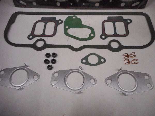 Koppakkingset with various gaskets and components laid out. Koppakkingset with various gaskets and components laid out.