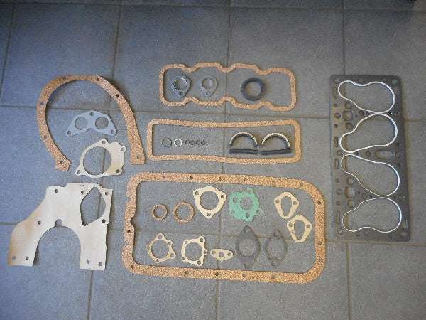 Motorpakkingset with various gaskets displayed on a tiled surface. Motorpakkingset with various gaskets displayed on a tiled surface.