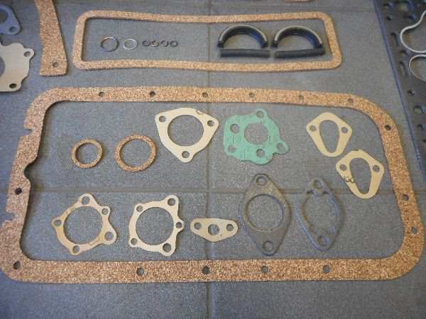 Motorpakkingset with various gaskets displayed on a tiled surface. Motorpakkingset with various gaskets displayed on a tiled surface.