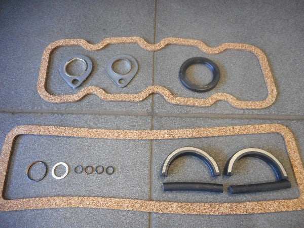 Motorpakkingset with various gaskets displayed on a tiled surface. Motorpakkingset with various gaskets displayed on a tiled surface.